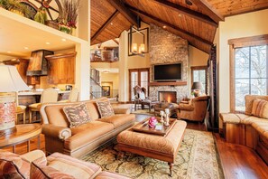 Mountain decor with hardwood flooring and vaulted wood beam and plank ceilings