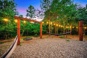Hammocks and a spider web swing hang beneath the twinkling string lights.