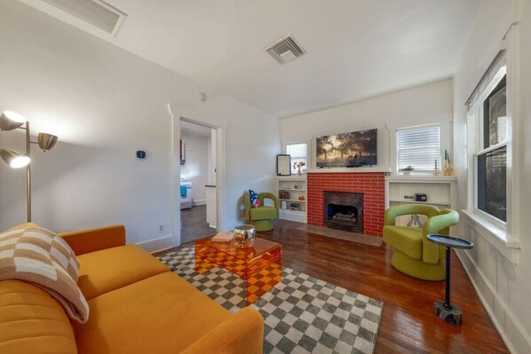 Living room with stylish, comfy seating, fireplace (decorative), and smart TV