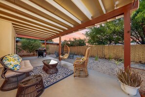Covered patio and yard area with lovely outdoor furniture, grill, and fire pit