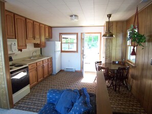 Upstairs kitchen off living room. Living room has door out to front deck