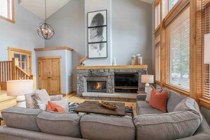 Living room features stone hearth, built-in gas fireplace, and flat screen tv with satellite and streaming options.