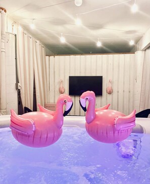 FlaminGO Cottage has a hot tub cabana with seating area, mini fridge & TV.  