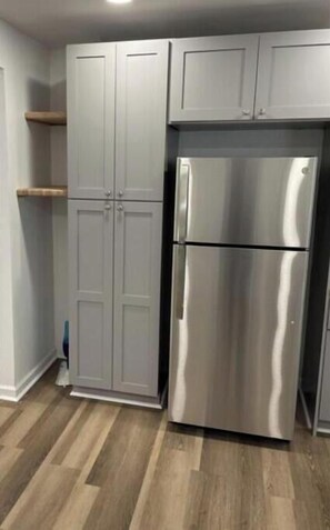 Stainless Steel appliances surrounded by butcher block counters and shelving
