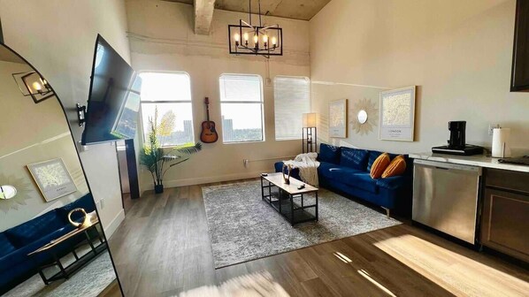 Living Room featuring an L shaped couch, flat-screen smart TV with FREE remote streaming services, and a stunning city view.