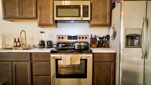 Our fully equipped kitchen is ideal for extended stays, featuring a stovetop, microwave, refrigerator with freezer, toaster, blender, and coffee machine.