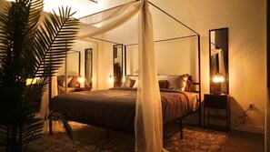 A romantic bedroom adorned with bedside lamps mirrored accents on either side of the bed, and a spacious closet.