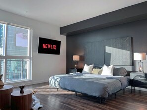 Cozy bedroom featuring a king-size bed, bedside table with lamp, and adjacent closet.