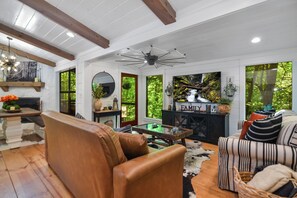 Open Concept living space with cozy seating, mounted smart TV with patio access