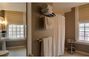 Enjoy a spacious shower in the well-appointed bathroom, designed for your comfort with modern amenities and abundant lighting.