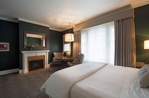 Rest peacefully in this elegant bedroom featuring a comfortable bed, cozy fireplace, and plenty of natural light.