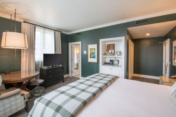 Relax in the comfort of a stylish bedroom with a cozy king bed, modern furnishings, and large windows.