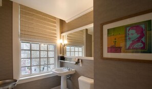 Refresh in the modern bathroom, featuring contemporary fixtures, abundant natural light, and chic artwork.