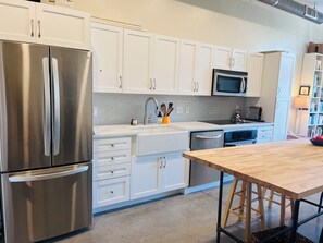 Kitchen area with high-top table and full refrigerator.