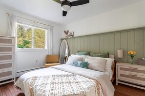 This bedroom includes dresser and a ceiling fan