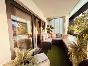 Cosy seating area at the end of the balcony, doors leading into master bedroom