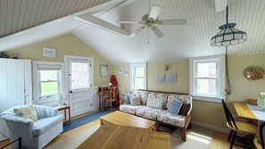 Main living area has a vaulted ceiling and ceiling fan
