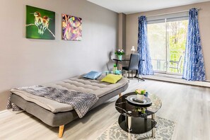 Bright Room With Sofa Bed And Desk Area Overlooking The Balcony