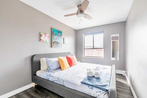 Spacious Bedroom With A King-Sized Bed, Bright Decor, And Large Windows