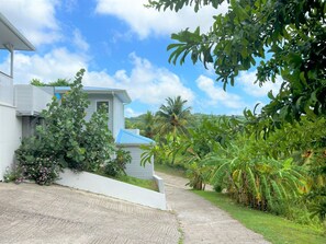 Profitez d’un cadre naturel verdoyant avec un stationnement privé directement devant votre villa.
