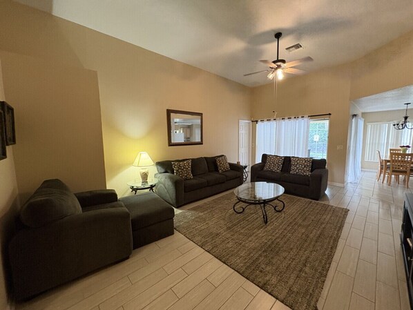 Spacious living area with plush seating and smart TV, perfect for relaxing after a day at the parks.