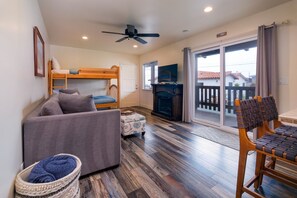 The living area features an electric fireplace, flat screen tv and comfy couch