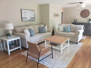 Bright family room with comfy couches and 2 sliders to deck