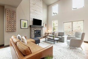 Living room with cozy sofas, gas fireplace, 50" Vizio smart TV, and patio access