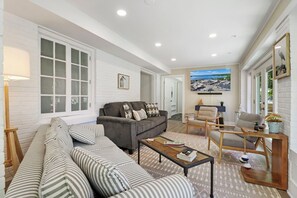 Living room with smart TV and Queen sofa sleeper. Entrance to furnished front deck.