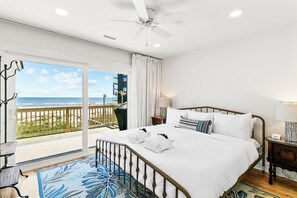 Primary bedroom with ocean views, porch access and a king sized bed.