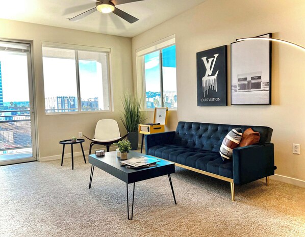Modern Cosmopolitan Style Apartment Living room with a sofa bed, Full size air mattress, and a 65" Smart TV with (Netflix, Hulu, Disney+ we logged them remotely) included for free.