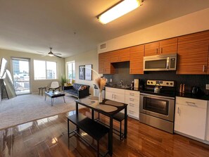 Fully furnished kitchen, ideal for extended stays, located next to the dining and living areas with a balcony view.