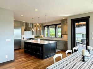 Well appointed kitchen with dining table and bar. Door to patio.