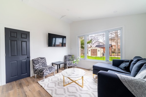 living room  filled with lots natural light. Stay informed by streaming the news or watch your favorite movies and TV shows using our 55 inch Smart TV.

