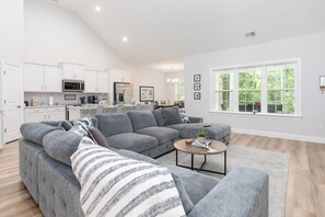 Unwind in style: This open living room invites you to sink into plush comfort, while the great TV promises endless entertainment, creating the perfect haven for relaxation and leisure.