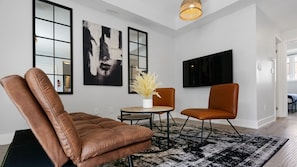 This modern living room is the perfect place to relax and unwind. The comfortable leather seating, stylish decor, and ample natural light create a welcoming atmosphere. Whether you're looking to curl up with a good book or entertain friends, this space has everything you need.