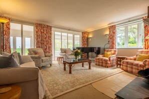 Saltingsgarth, Brancaster: Sitting room with comfortable seating and piano