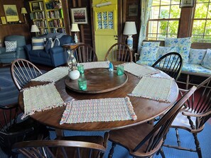 large round dining table with library and couches in background