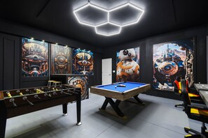 Galactic game room with pool, foosball, and Star Wars-inspired wall art
