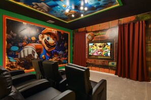 Mario-themed home theater with cozy recliners and vibrant gaming wall art
