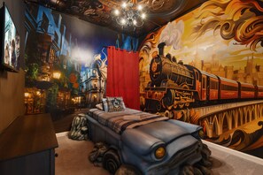 Wizard-themed room with flying car bed and magical train mural for young fans
