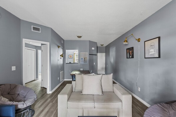 A modern living room with sofa, sofabed, 43" Roku, spacious with 9' ceiling. 