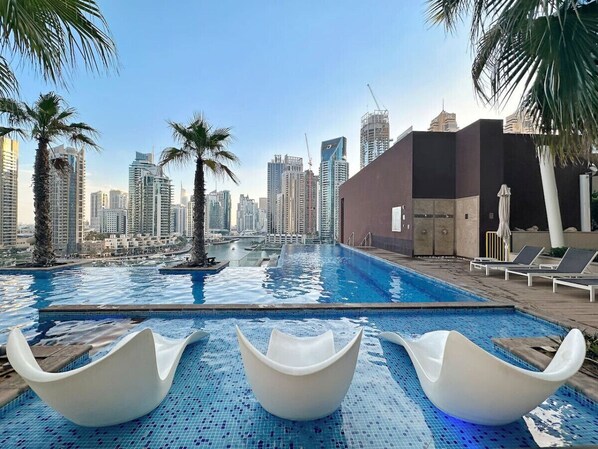 Infinity Pool Oasis: Relax in sleek loungers with stunning skyline views and shimmering waters!