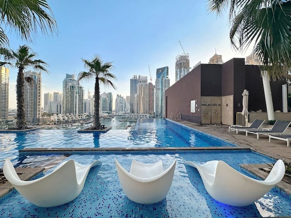 Infinity Pool Oasis: Relax in sleek loungers with stunning skyline views and shimmering waters!