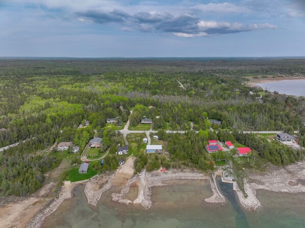 Aerial view of Len Cove and the quiet beauty of Howdenvale—Lake Huron’s sparkling shoreline and lush forest set the scene for a peaceful retreat.

