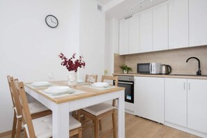 Modern kitchen with white cabinets and dining table,