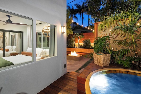Cedar Hot Tub with backdrop of bistro lights and natural gas fire pit.