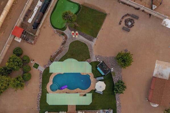 Resort backyard sitting on more than 1 acre includes a crystal clear diving swimming pool, putting green, fire pit, lounge chairs, mature citrus trees, 1,000 sq.ft artificial grass & 1,000 sq.ft real grass. 