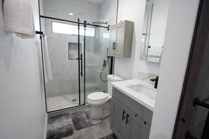 Welcome to our modern bathroom with glass shower door and toilet!