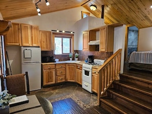The kitchen has a fridge, microwave and gas oven.